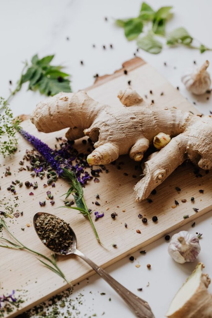 Close-up of fresh ginger and various spices laid out on a chopping board for culinary use.